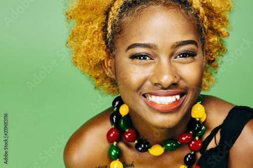 Fotografie, Obraz Close up of a very happy young girl with big smile and colorful necklace, in fro