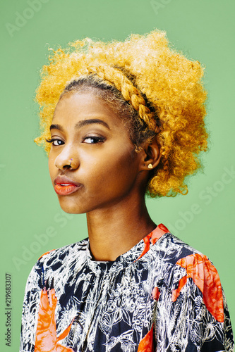 Cuadros en Lienzo Portrait of a lovely young girl with bleached curly hair looking at camera, in f