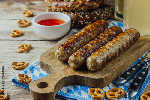 Fotografie, Obraz Rustic background for Oktoberfest or Bavarian specialties with white and blue fabric, beer glass and pretzels on wooden table