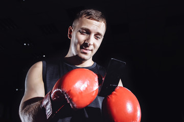 Male boxer using a phone after a workout