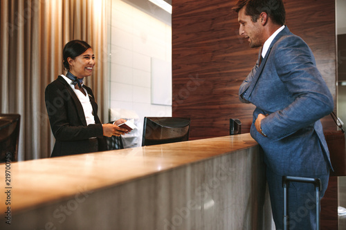 Cuadros en Lienzo Businessman checking in at hotel reception