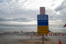 Beach Warning Signs No Cats Dogs Submerged Rocks With Cones In Background