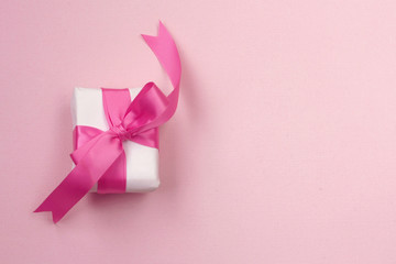 Wall Mural - wrapped gift box with pink bow, on paper texture background