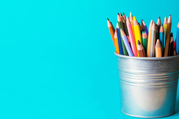 bucket with pencils on a blue background