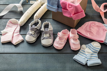 Wall Mural - Baby boy and girl shoes and socks on blue wooden background