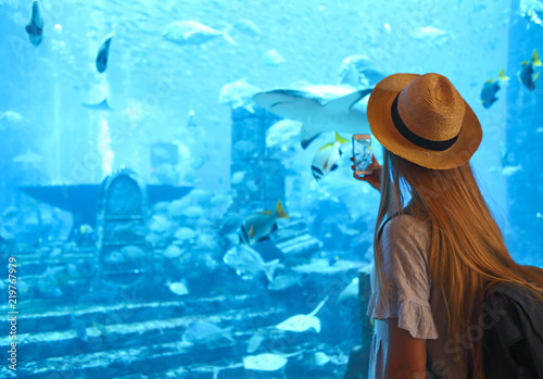 Fotografía Sillouette of the woman taking picture in large aquarium
