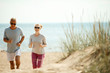 © pressmaster - Cheerful and active couple of retired spouses jogging in the morning on the beach