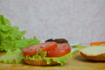 Home made hamburger with beef, onion, tomato, lettuce and cheese. Fresh burger closeup on wooden rustic table