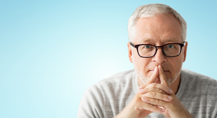 old age, problem and people concept - close up of senior man in glasses thinking