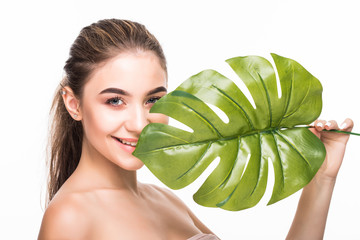 Beauty smiling woman with natural make up and green leaf on white background. Spa and wellness. Skin care concept.