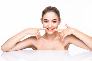 Wall Mural - Beautiful young woman pointing on her perfect white teeth isolated on white background. Health care concept.