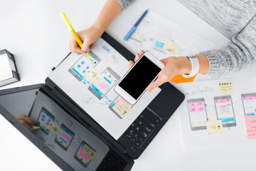 app design, technology and business concept - web designer or developer with smartphone working on u