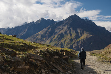 Wall Mural - a man walking on empty road with mountain view