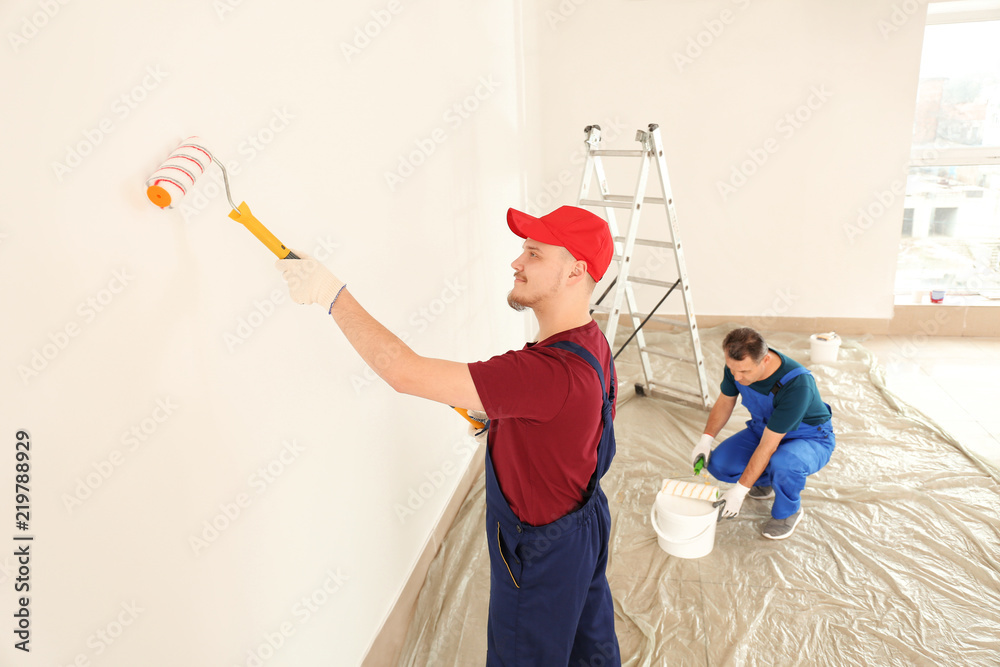 Male painters in uniform working indoors