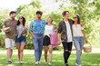 © Syda Productions - friendship and leisure concept - group of happy friends with picnic blanket and watermelon walking at summer park