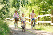 © Syda Productions - family, leisure and people concept - happy mother, father and little daughter riding bicycles in summer park