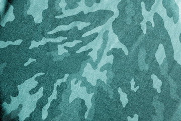 Old camouflage cloth with blur effect in cyan tone.