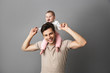 © Drobot Dean - Image of happy father man carrying his little child on neck, isolated over gray background