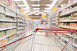 © Kwangmoozaa - Empty shopping cart with abstract blur supermarket discount store aisle and product shelves interior defocused background