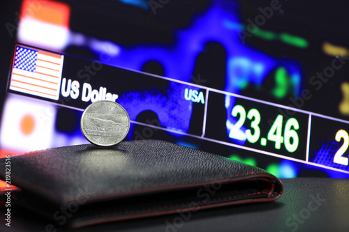 Fotografía A quarter of US Dollar coins on reverse (USD) on black wallet on black floor with digital board of currency exchange money background, the concept of finance