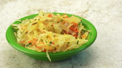 Canvas Print - eating with fork a sauerkraut salad - white fermented cabbage with carrot, chive, caraway seeds and olive oil