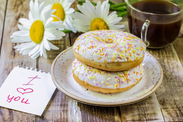 breakfast with donut and coffee. Two donut and a cup of coffee with chocolate on a wood table