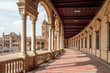 The porticoed gallery and hallway with columns and tiled floor in Plaza de Espana, Seville Spain