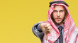 © Krakenimages.com - Young handsome arabian man with long hair wearing keffiyeh over isolated background looking unhappy and angry showing rejection and negative with thumbs down gesture. Bad expression.