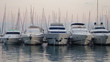 Five boats moored in Split harbour at early evening, on the water with boat masts behind
