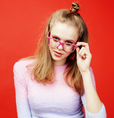 young pretty teenage girl on bright red background, happy smilin