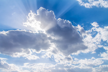 the rays of the sun from behind the white clouds