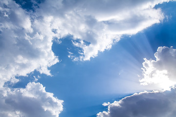 The rays of the sun from behind the white clouds