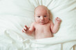 © irena_geo - Newborn baby looking surprised at the camera in white bed. Family, new life, childhood, beginning concept