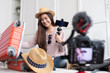 © weedezign - Asian young female blogger recording vlog video with vacation preparing to travel trip at home.online influcencer on social media concept.