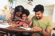 Mom and dad drawing with their daughter. African american family spending time together at home.