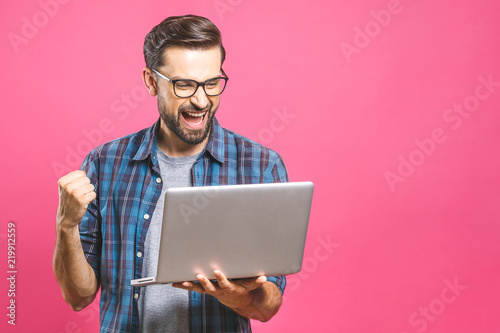 Fotomural I'm a winner! Happy man holding laptop and celebrating his success over pink background