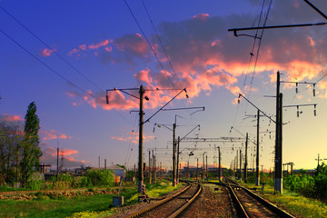 Two lines railway at the country side on the beautiful sunset sky background. Electric poles at railroad.