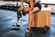 Cropped image of european disabled invalid woman wearing prosthesis in tracksuit, training and lifting dumbbell in gym