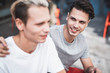 © Yakobchuk Olena - Positive male telling with smiling comrade while putting arm on his shoulder. Glad guys during conversation concept
