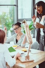 Wall Mural - Professional young businesswomen discussing while working together at office