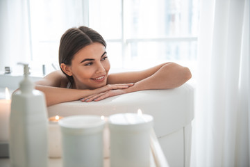 Wall Mural - Portrait of beaming lady with attractive smile resting in bathroom in apartment