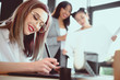 © LIGHTFIELD STUDIOS - young designer drawing on graphics tablet while her colleagues looking at blueprint