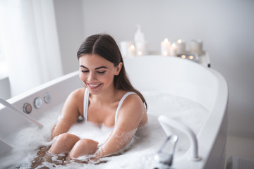 Wall Mural - Portrait of optimistic female relaxing during treatment procedure in water. She closing eyes