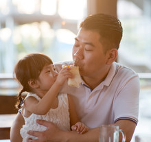 Little Girl Feeding Daddy Bread
