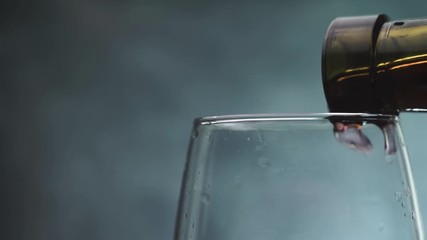 Poster - Pouring  glass of red wine close up, rotation 360 degrees on a dark background.