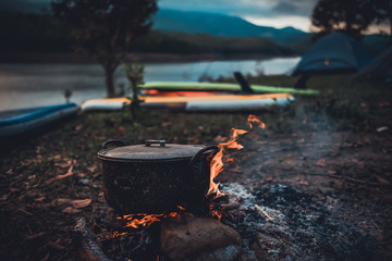 camp and cooking in field conditions, boiling pot at the campfire on picnic in morning. cooking dinn