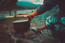 Camp And Cooking In Field Conditions, Boiling Pot At The Campfire On Picnic In Morning.  Cooking Dinner On Firewood Stove Using Firewood When Going To The Wilderness Or Outdoor Activity, Camping Tent