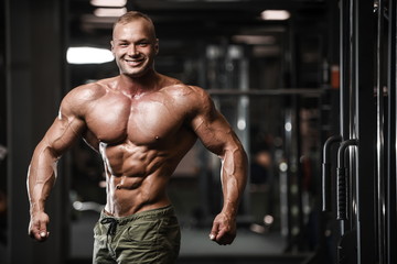  Handsome strong bodybuilder athletic men pumping up muscles with dumbbells