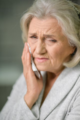 Wall Mural - Close up portrait of senior woman with toothache