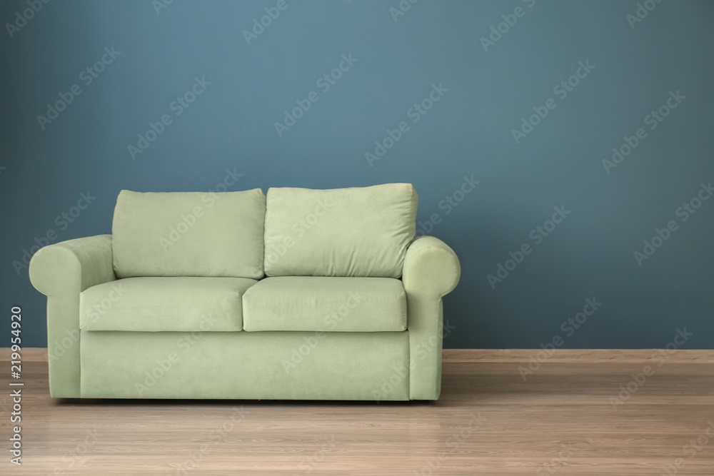 Comfortable sofa near color wall